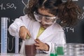 Focused scientist kid mixing chemicals in flasks Royalty Free Stock Photo