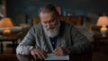 Portrait greyhaired gentleman signing contract indoors. Man reading documents.