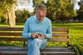 Focused senior man counting coins from his wallet while sitting on bench Royalty Free Stock Photo