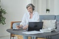 A focused senior mature old lady instructor using laptop camera to coordinate distance learning. Royalty Free Stock Photo