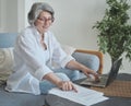 Focused senior woman using computer for research and creative work Royalty Free Stock Photo