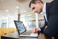 Focused serious business man working with laptop in conference hall