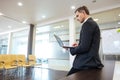 Focused serious businessman preparing for presentation using laptop