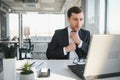 Focused serious businessman in suit thinking reading online news or solving business problem working on laptop looking Royalty Free Stock Photo