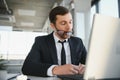 Focused serious businessman in suit thinking reading online news or solving business problem working on laptop looking Royalty Free Stock Photo