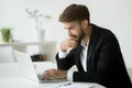 Focused serious businessman thinking reading online news using l Royalty Free Stock Photo