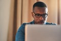 Focused, serious and confident entrepreneur typing on a laptop and reading an email sitting alone in his home office Royalty Free Stock Photo