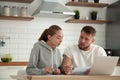 Focused serious couple checking bills sitting together at kitche