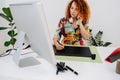 Focused artist woman talking on the phone while painting behind work desk Royalty Free Stock Photo