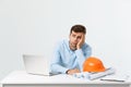 Focused serious hardworking engineer busy working on big architectural project late, sitting at his workspace using