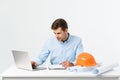 Focused serious hardworking engineer busy working on big architectural project late, sitting at his workspace using Royalty Free Stock Photo