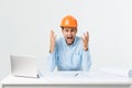 Focused serious hardworking engineer busy working on big architectural project late, sitting at his workspace using