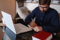 Focused serious male student using laptop looking at computer screen