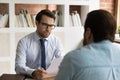 Focused hr manager in eyeglasses holding interview with job applicant. Royalty Free Stock Photo