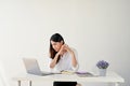 Focused and serious Asian businesswoman working on her assignment on her laptop at her desk Royalty Free Stock Photo