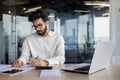 A focused and serious young Indian man works as an accountant, auditor, and financial analyst. Sitting at the desk in Royalty Free Stock Photo