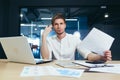 Focused and serious young man IT specialist, manager, businessman working on laptop and with documents in the office at the desk. Royalty Free Stock Photo