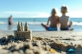 Focused shot of a sandcastle on a beach with blurred children and ocean in the background Royalty Free Stock Photo