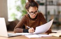 Focused smart young african american woman working online on laptop or female student studying online at home Royalty Free Stock Photo