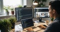 Focused software developer working at a bright desk with multiple monitors and plants Royalty Free Stock Photo