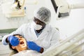 Focused stomatologist treating teeth to female patient in dental office