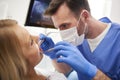 Focused stomatologist treating woman for dental cavity