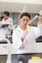 A focused student pouring liquid in a tube Royalty Free Stock Photo