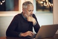 Focused on the task at hand. a mature businessman working late at the office. Royalty Free Stock Photo