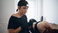 Focused tattooist holding machine at home closeup. Woman changing consumable