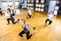 Focused team doing split squats with weights at fitness gym Royalty Free Stock Photo