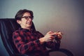 Focused teen boy playing video games late night seated in his chair. Angry and furious guy nerd wearing glasses, holding the Royalty Free Stock Photo