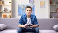 Focused teenage boy playing video game at home, gadget addiction in awkward age Royalty Free Stock Photo