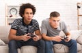 Focused teens playing video games together on couch Royalty Free Stock Photo