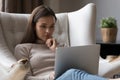 Focused thoughtful pretty young woman using laptop at home Royalty Free Stock Photo