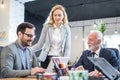 Focused three office workers planning work together listening to mentor coach teaching using laptop in office. Royalty Free Stock Photo