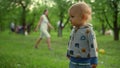 Focused toddler standing outside. Happy mother and son playing with ball in park Royalty Free Stock Photo