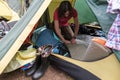 Focused tourist is twisting a camping inflatable mat while sitting in a tent. End of the hike, collection of things and