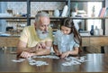 Focused two generations of family playing puzzle game together