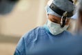 Focused on a very precise procedure. a surgeon performing a surgery in an operating room.