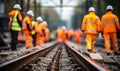 Focused View on Railway Tracks with Blurred Background of Railroad Workers in High Visibility Clothing Inspecting the Site Royalty Free Stock Photo