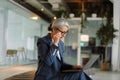 Focused white-haired businesswoman using laptop while sitting Royalty Free Stock Photo