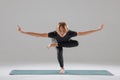 Woman practicing advanced yoga pose with deep balance and core focus indoors. Royalty Free Stock Photo