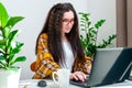 Focused woman in glasses typing on laptop keyboard is working at home, writing emails, online shopping or watching video Royalty Free Stock Photo