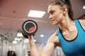 Focused woman lifting dumbbell while sitting down