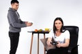 A focused woman is playing a game while her boyfriend is cleaning the dishes. White background and gender stereotypes