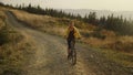 Focused woman riding sport bicycle on road. Cyclist exercising in mountains