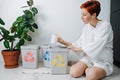 Focused woman sorting garbage beween small recycle bins at home Royalty Free Stock Photo