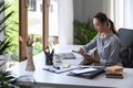 Focused working woman using laptop and writing ideas in a notebook. Royalty Free Stock Photo