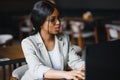 Focused young african american businesswoman or student looking at laptop, serious black woman working or studying with computer Royalty Free Stock Photo