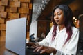 Focused young african american businesswoman or student looking at laptop, serious black woman working or studying with computer Royalty Free Stock Photo